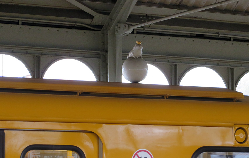 High above the trains, Berlin's fairytale Frog Prince surveys the platform at Prinzenstrasse station